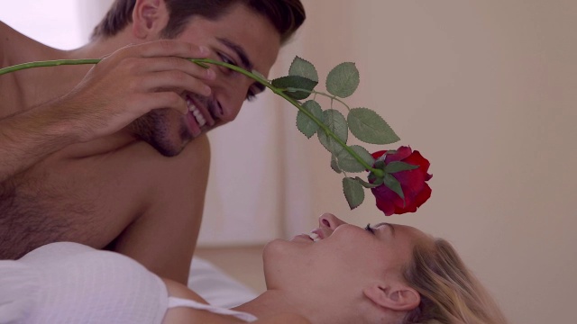男子在床上用一朵红玫瑰给女友搔痒视频下载