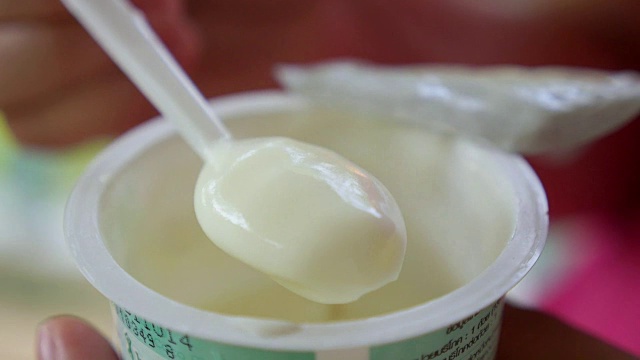 用勺子吃新鲜酸奶的特写。健康的生活方式视频下载