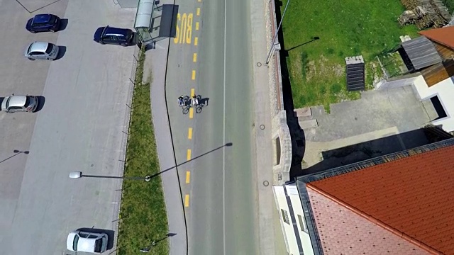 骑电动自行车的人穿过公共汽车站视频下载