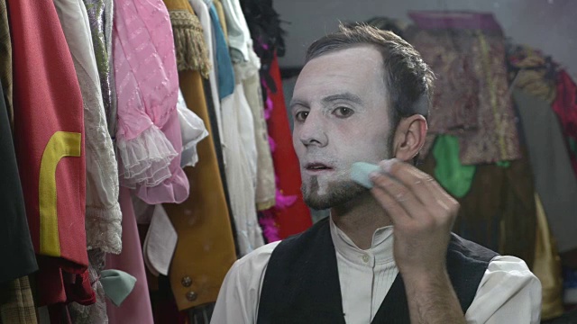 英俊的年轻男演员正在用白色的面霜化妆视频素材