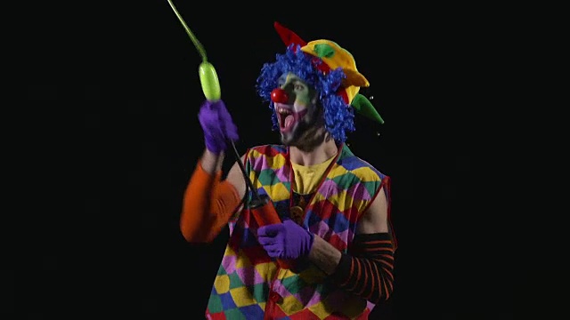 年轻有趣的小丑正在给气球充气视频素材