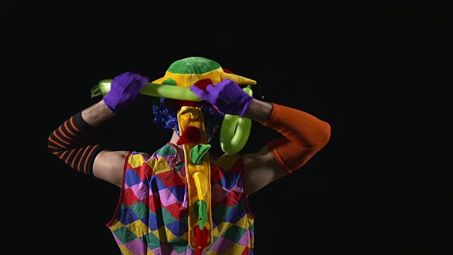 年轻有趣的小丑用气球做了一把剑视频素材