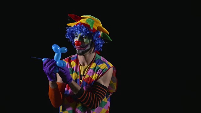 年轻有趣的小丑用气球做贵宾犬视频素材