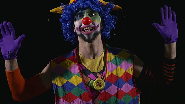 年轻滑稽的小丑做着滑稽的鬼脸视频素材