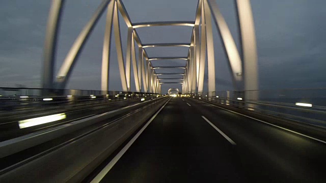 黄昏的后视图开车通过灯火通明的东京门大桥。视频素材