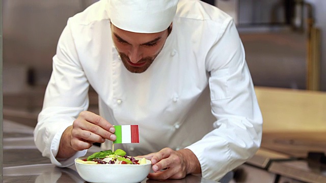 帅气的厨师把意大利国旗放在菜上视频素材
