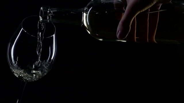 白葡萄酒被倒进酒杯，轮廓，黑色，缓慢的动作视频下载