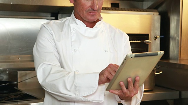 英俊的厨师使用平板电脑和做ok标志视频素材