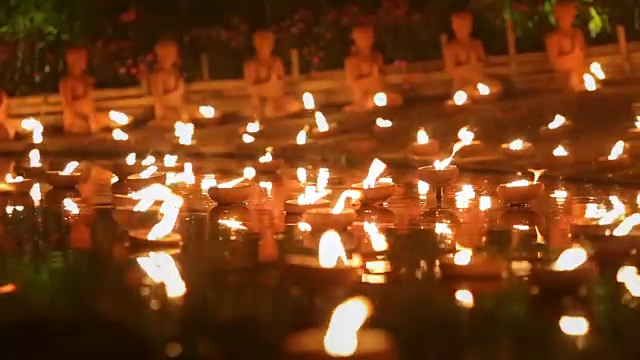 泰国清迈，大斋日，僧侣为佛陀点燃蜡烛视频下载
