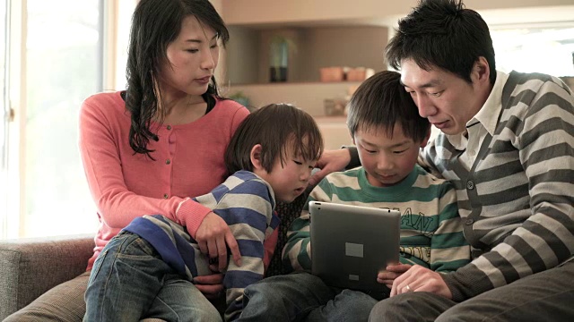两个儿子使用智能手机和数字平板电脑视频素材