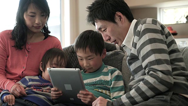 两个儿子使用智能手机和数字平板电脑视频素材