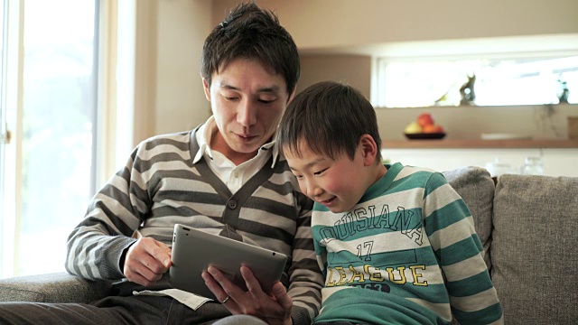 父亲和儿子在用数码平板电脑视频素材