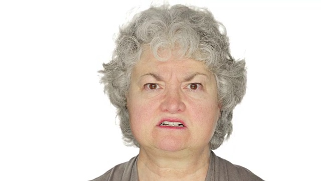 在一个白色的摄影棚背景上，一个成熟的女人愤怒地摇着头视频素材