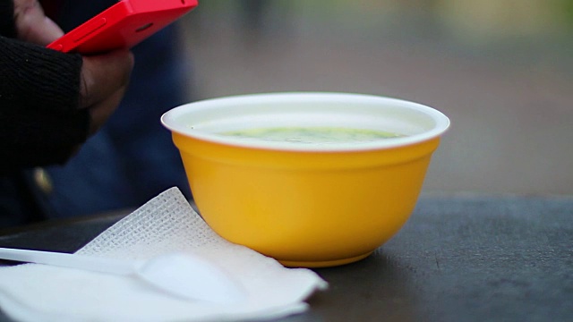 塑料碗里的热汤是在户外给卑微的工人喝的，视频素材