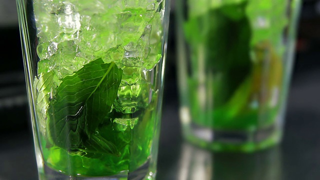 酒保在杯子里倒入绿色糖浆视频素材