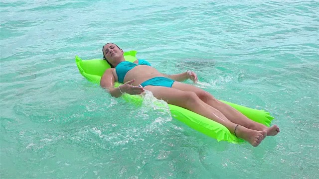 慢动作:放松的女人躺在充气床垫上视频下载