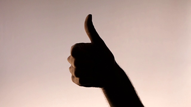 手的姿势。竖起大拇指。轮廓男性的手在梯度粉红色的背景视频下载