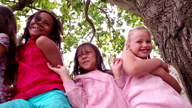 夏天，小女孩们坐在树屋下的篱笆上视频素材