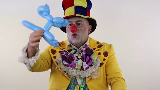 小丑使气球狗在白色的背景视频素材