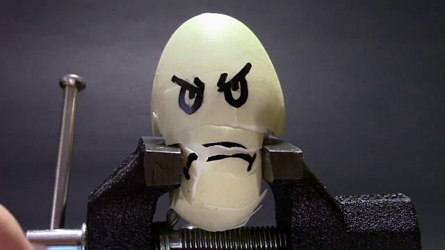 画着悲伤脸的鸡蛋被金属虎钳夹在中间，关于压力和健康相关问题的概念性画面视频下载
