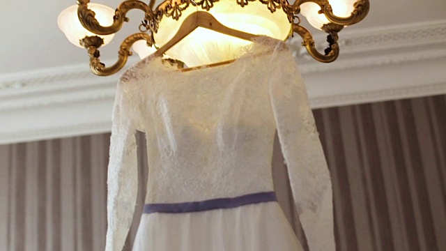 优雅的婚纱挂衣架专门为一个年轻的新娘的婚礼仪式。视频下载