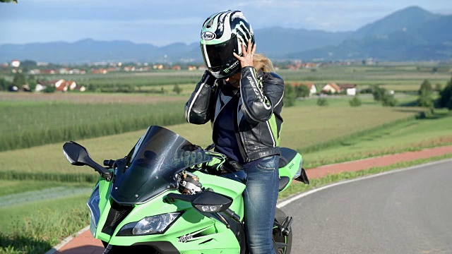 骑摩托车的女士摘下头盔，面带微笑视频下载