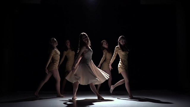 开始五个女孩的现代舞，穿着白色的衣服，在黑色，阴影，慢动作视频下载