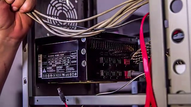 一个修理工正在试着连接电脑内部的电线视频下载