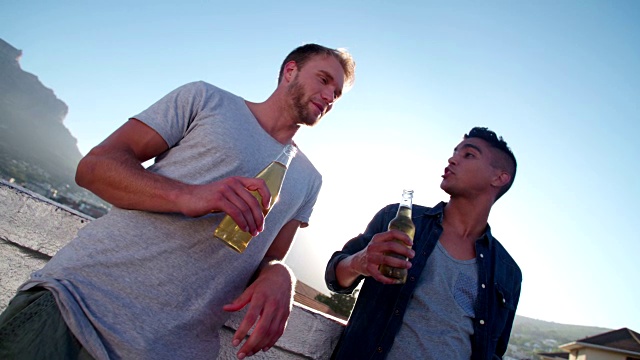 两个朋友在屋顶上庆祝，用啤酒敬酒视频下载