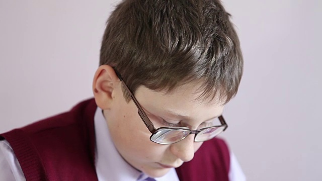 戴眼镜的男孩在学校玩平板电脑视频下载