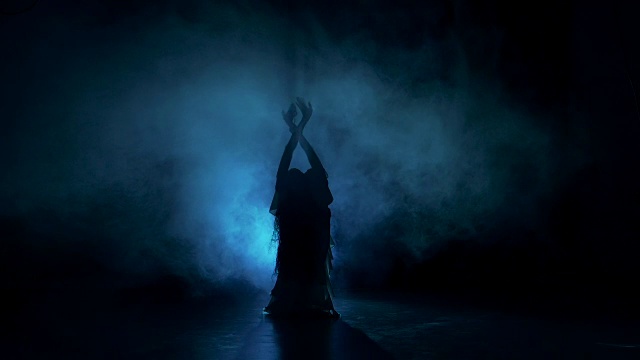 脱衣舞女开始在黑暗中跳舞，阴影，烟雾，剪影视频下载