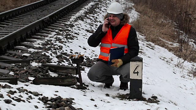 铁路工人在铁路附近用智能手机记录通话视频下载