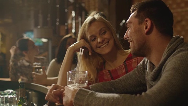 男人和女人在酒吧里欢笑、喝酒、享受美好时光。视频素材