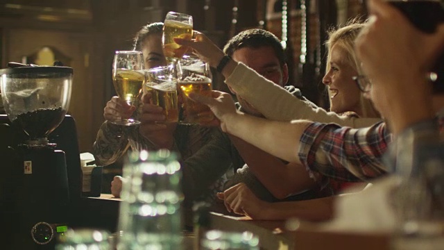 朋友们一起在酒吧举杯祝酒，喝啤酒和鸡尾酒，共度美好时光。视频素材