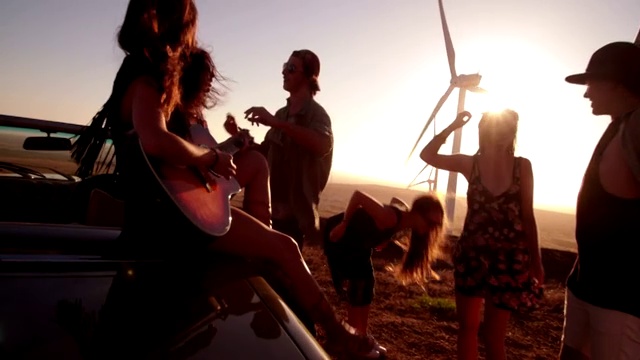 年轻的成年女孩和朋友在户外弹吉他视频素材