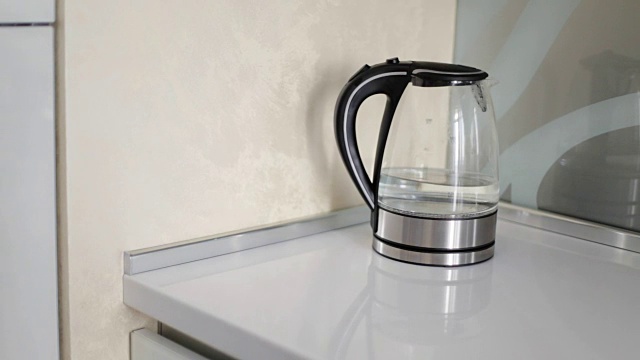 近距离的女人打开现代玻璃电水壶在厨房。视频素材