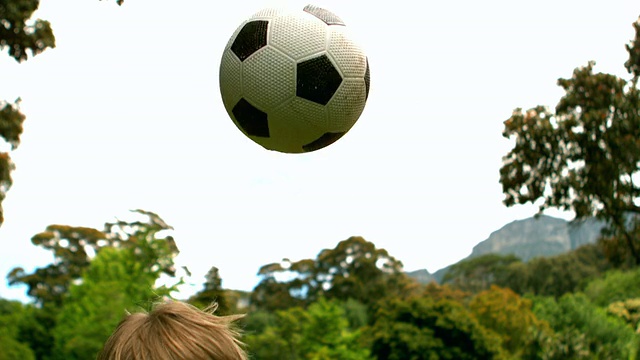 小男孩在公园里踢足球视频素材