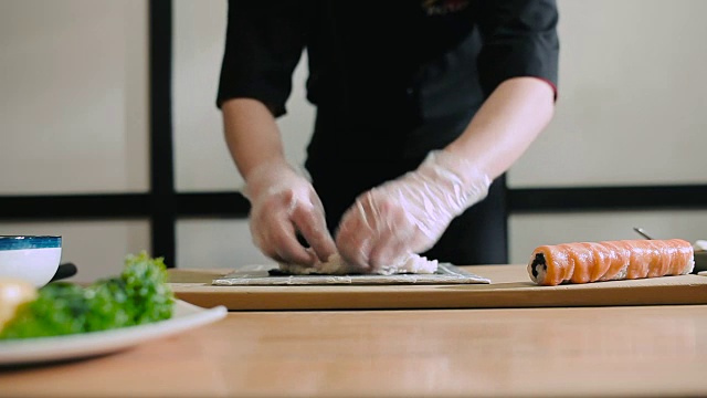 寿司师傅把米饭涂在海苔上视频素材