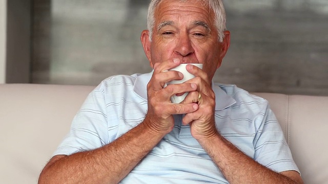 坐在沙发上喝咖啡的老人视频素材