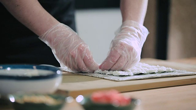 寿司师傅正在为寿司卷准备米饭视频素材