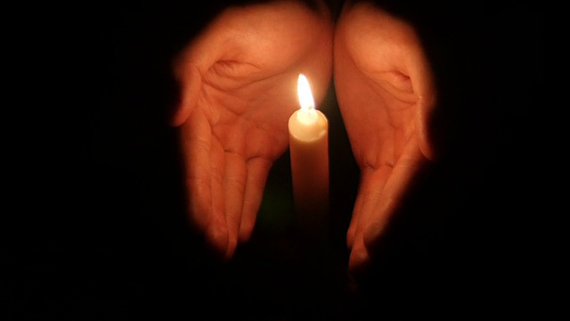 黑暗中，双手举着燃烧的蜡烛视频下载
