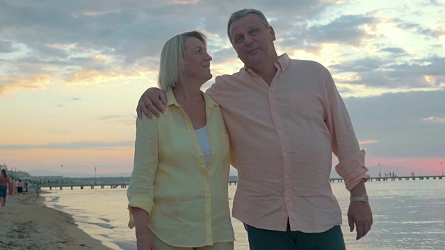 相爱的成熟夫妇在海滩上散步视频素材