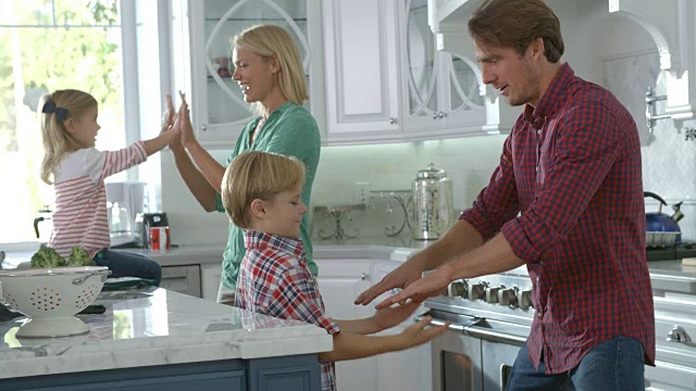 家庭在现代厨房玩游戏，慢动作视频素材