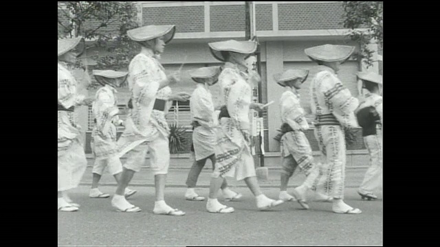在博多东拓节游行中，参与者穿着服装弹奏传统乐器。视频下载