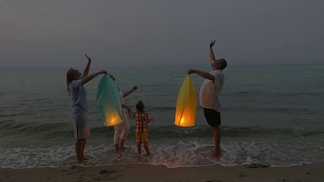 一家人在海滩上放飞天灯视频素材