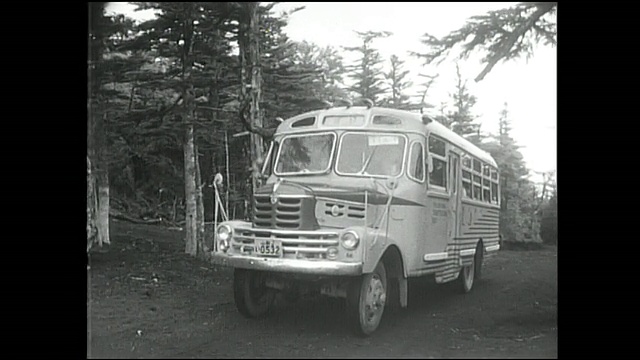 一辆旅游巴士在富士山第五站附近的山路上行驶。视频素材
