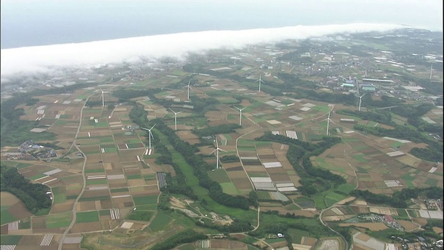 风力涡轮机在日本海岸附近的农田上运行视频素材