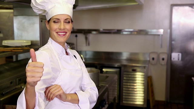 漂亮的厨师对着镜头微笑，竖起大拇指视频素材