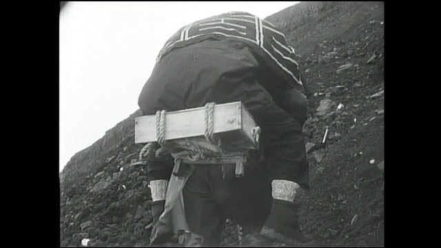 一名登山者背着另一名男子爬上富士山。视频素材
