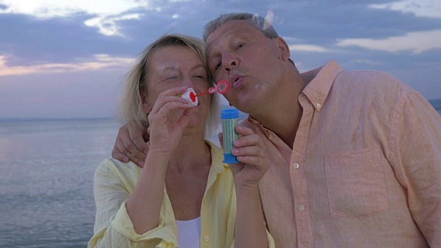 成熟的夫妇在海边吹泡泡视频下载